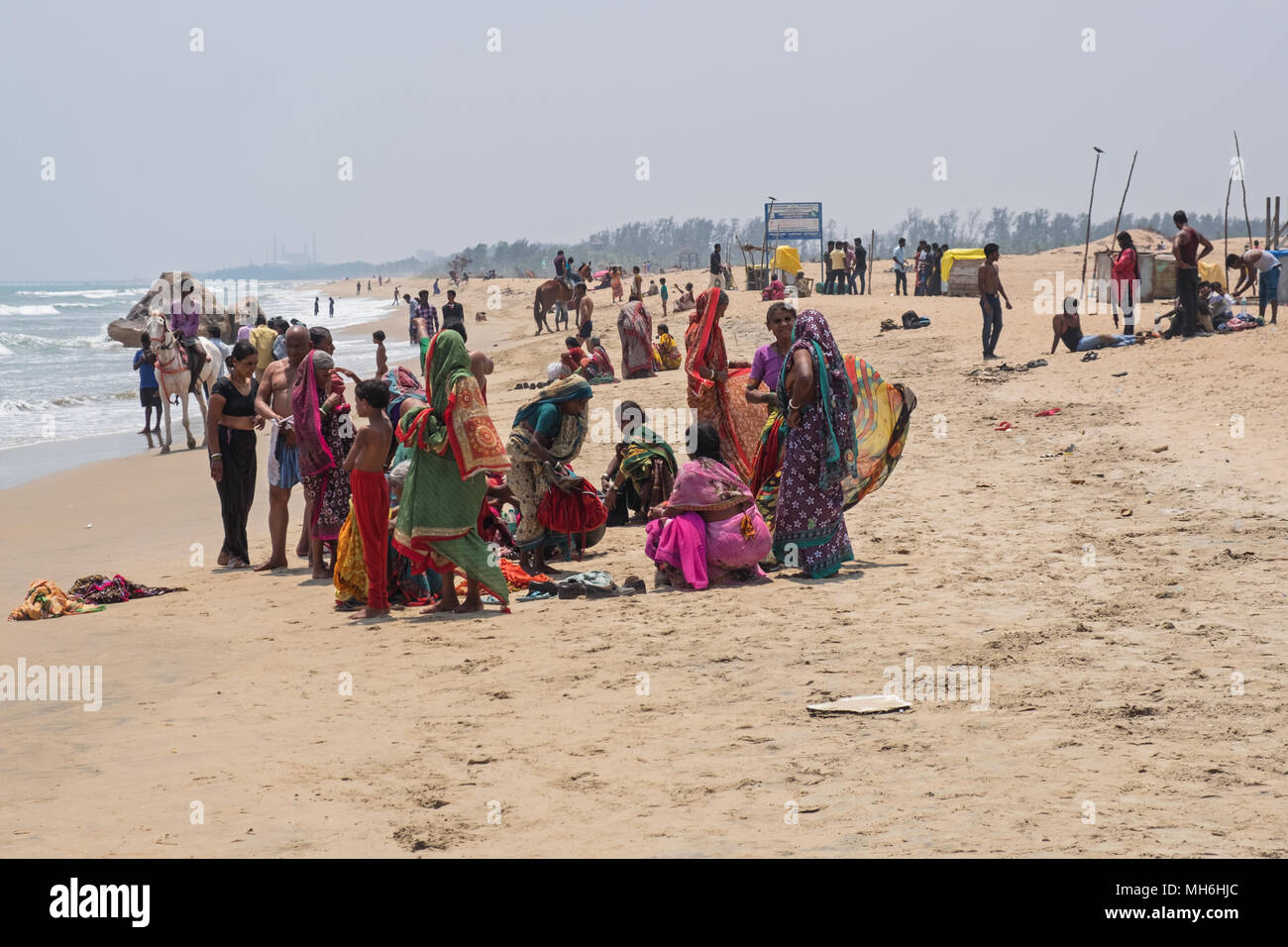 Mahabalipuram, India - 20 Marzo 2018: persone si sono radunate sulla spiaggia per godervi le acque rinfrescanti della Baia del Bengala sulla costa di Coromandel Foto Stock
