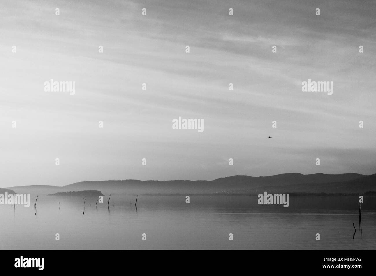 Bellissima vista del lago Trasimeno (Umbria, Italia), con colline e cielo riflettendo sull'acqua Foto Stock