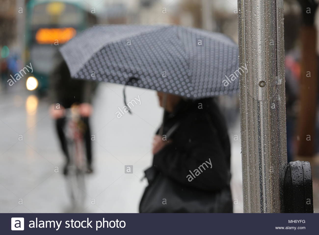 In un giorno di pioggia a Dublino i cieli nube su in O'Connell street come la previsione diventa tetro e gocce di pioggia di raccogliere il traffico sul palo della luce Foto Stock