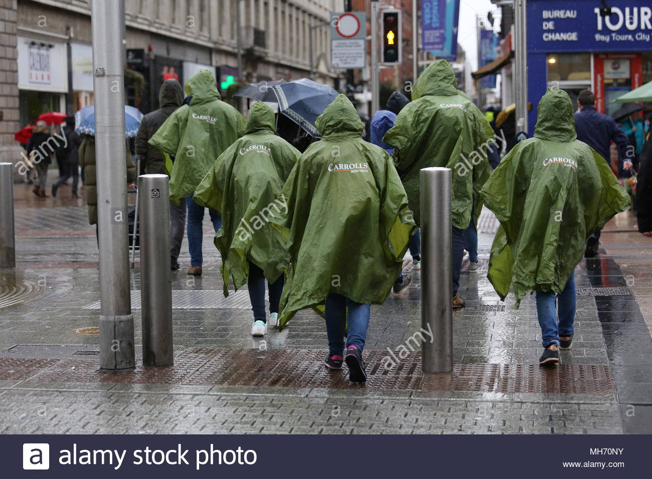 In un giorno di pioggia a Dublino persone attraversano O'Connell Street. Foto Stock