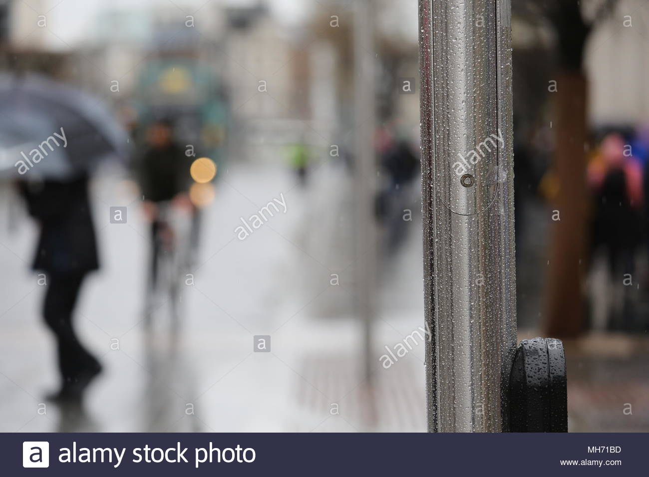 Un uomo attraversa O'Connel Street in Dublim in un giorno di pioggia. Foto Stock