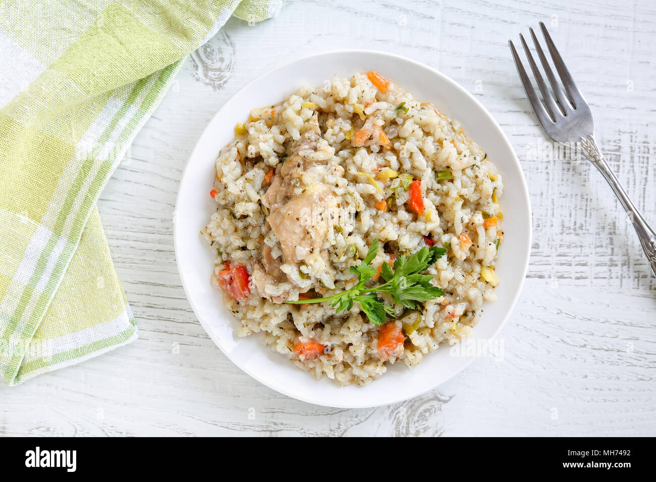 Vista dall'alto di una deliziosa, fatti in casa tradizionale bulgara spezzatino di pollo con riso e verdure in piastra bianca su una tavola in legno rustico. Foto Stock