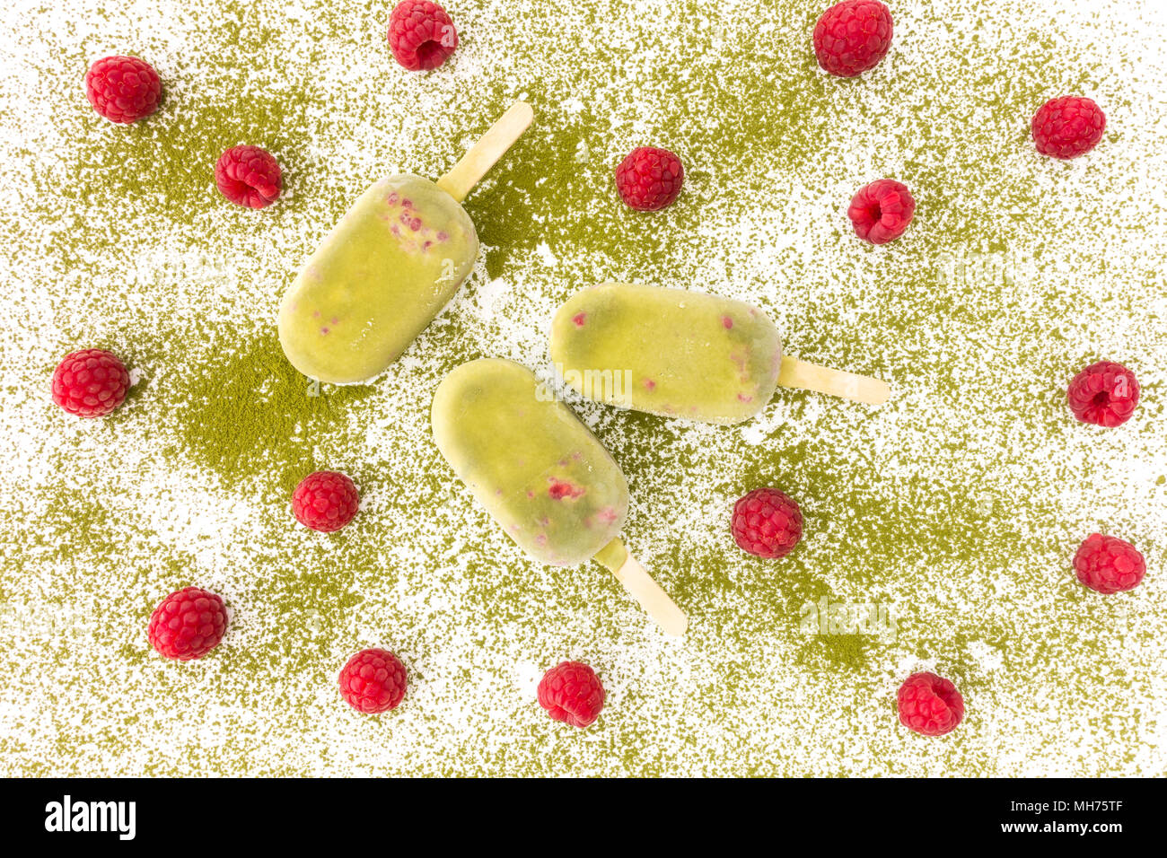 Matcha e lampone Popsicles e lamponi freschi sul matcha in polvere. Vista dall'alto. Foto Stock