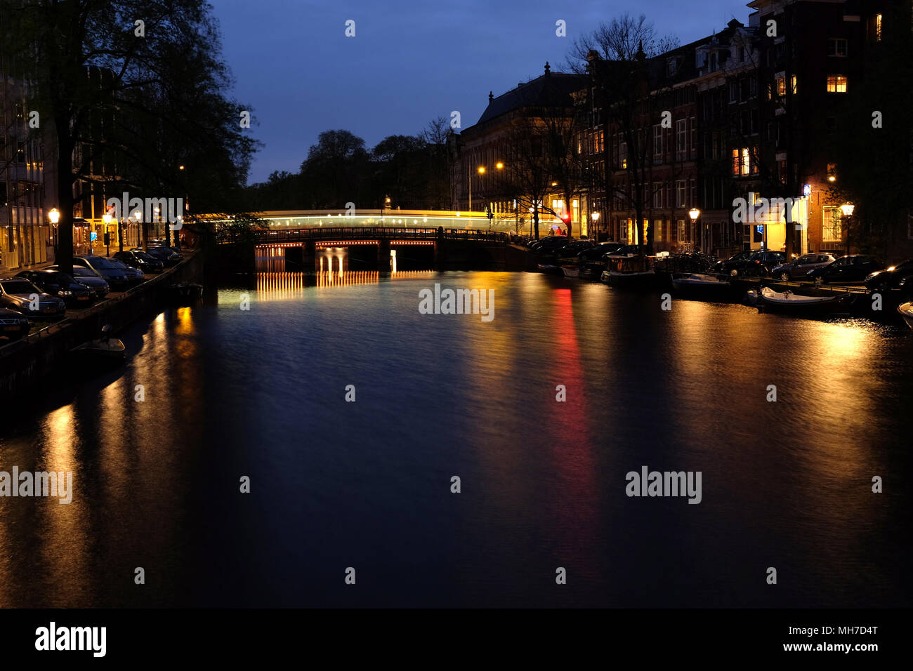 Edifici di Amsterdam e canal con riflessi sull'acqua di notte sullo sfondo Foto Stock