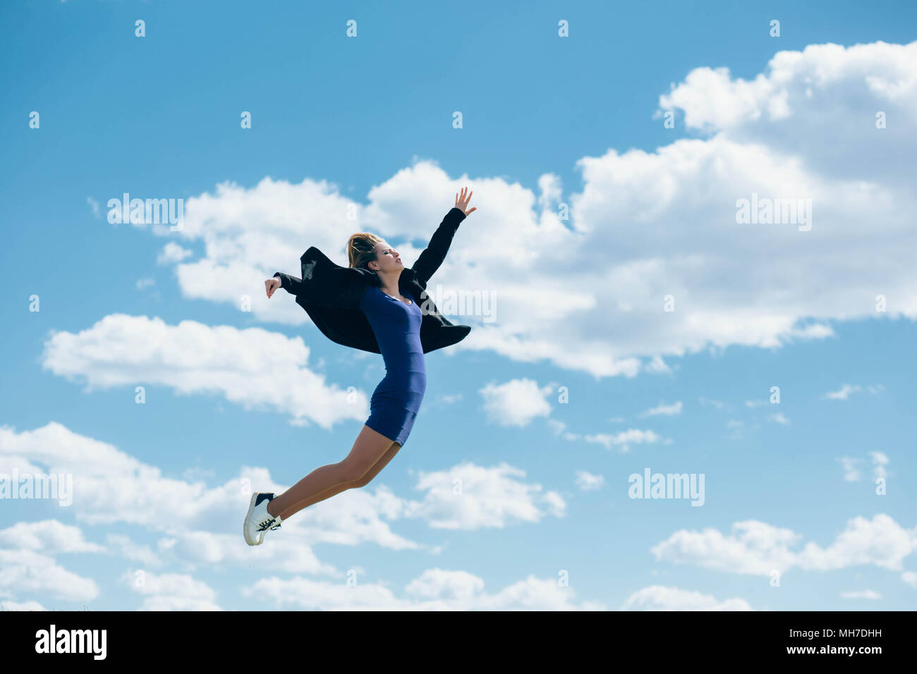 Jumping donna sullo sfondo del cielo Foto Stock