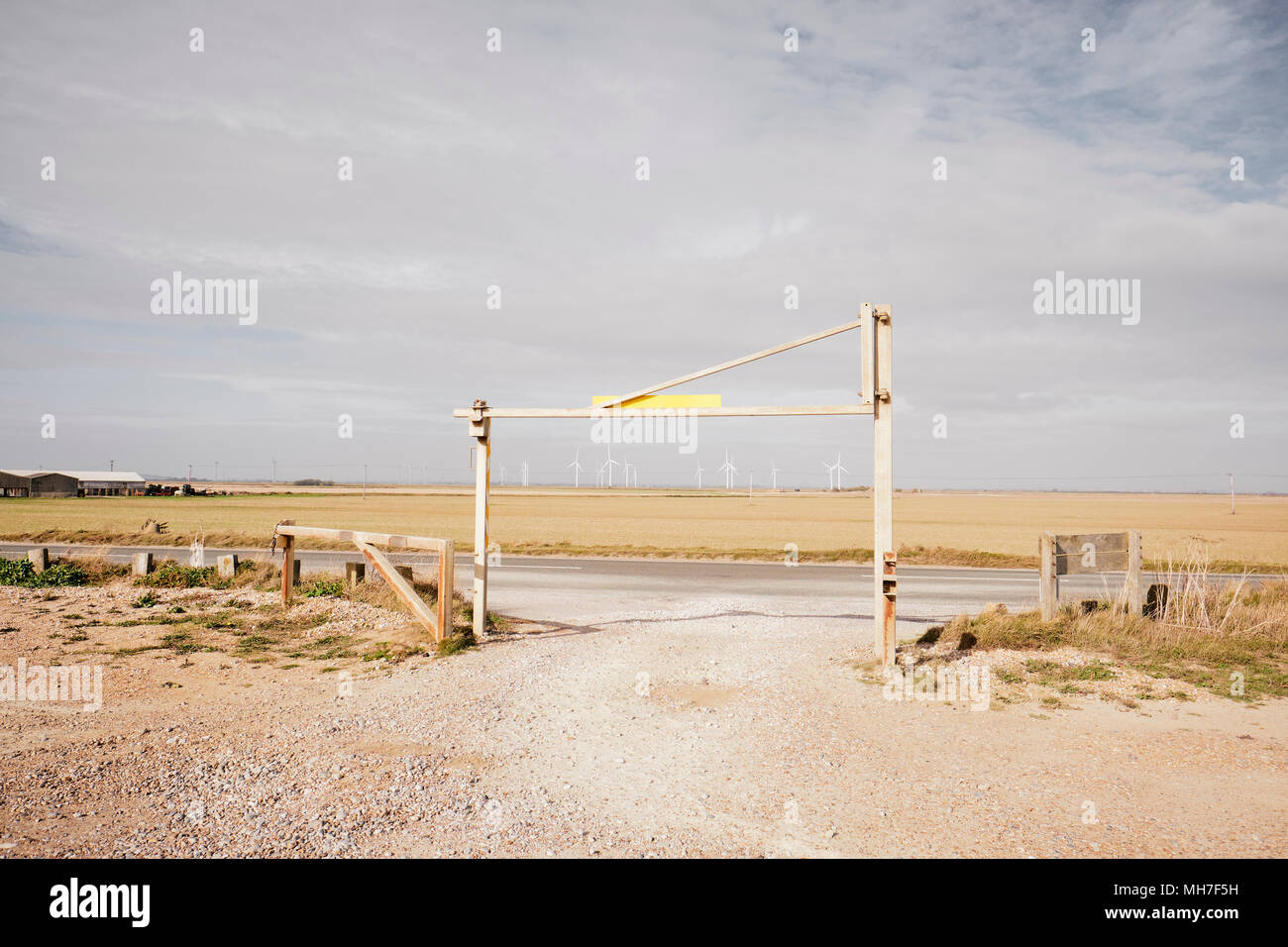 Un vuoto di limitata altezza ingresso del parco auto che assomiglia a un obiettivo con una wind farm in distanza. Inghilterra, Regno Unito Foto Stock