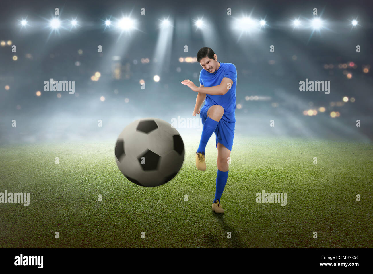 Giovani asiatici giocatore di calcio ripresa la palla sul campo Foto Stock