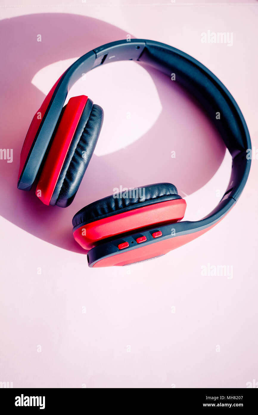Rosso nero cuffie senza fili isolati su sfondo rosa e area di pubblicità come la tecnologia digitale .bluetooth e percorso di clipping.ascolto un concetto di musica. Foto Stock