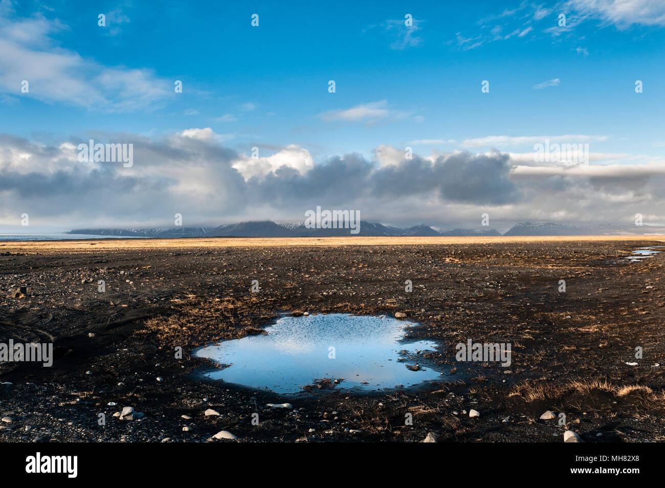 A sud dell'Islanda. L'anello strada attraversa il vasto di lava nera Sandur Skeiðarár (dilavamento plain) causati da inondazioni glaciale. Skaftafell nella distanza Foto Stock