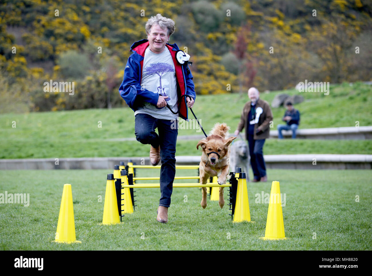 Candidato David Torrance MSP e il suo cane Buster affrontare il percorso ad ostacoli che prendono parte all'Holyrood cane dell'anno 2018 presso il parlamento scozzese di Edimburgo. Foto Stock