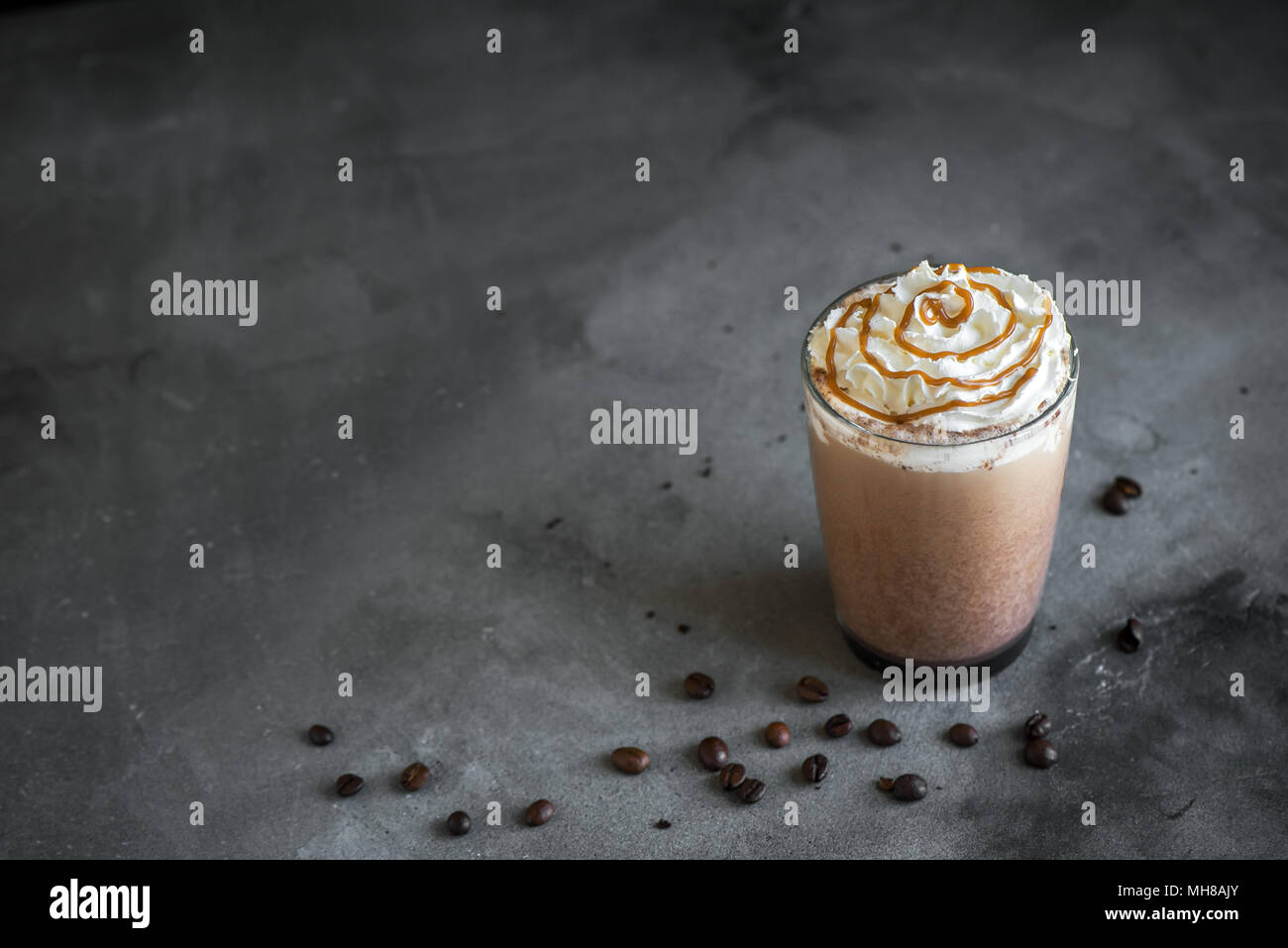 Il freddo Frappé Caffè (frappuccino) con panna montata e caramello su sfondo scuro, copia dello spazio. Foto Stock