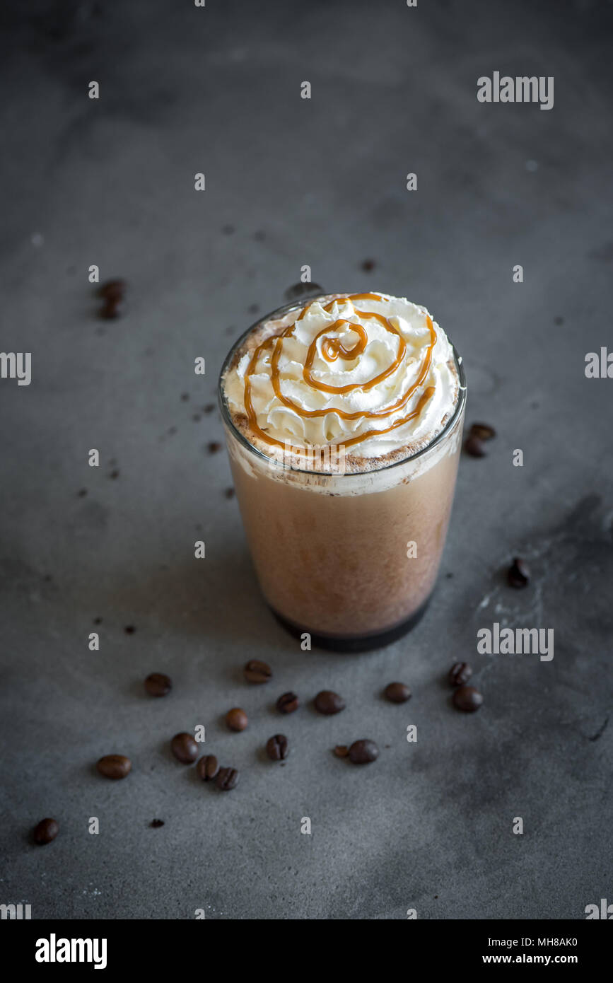 Il freddo Frappé Caffè (frappuccino) con panna montata e caramello su sfondo scuro, copia dello spazio. Foto Stock