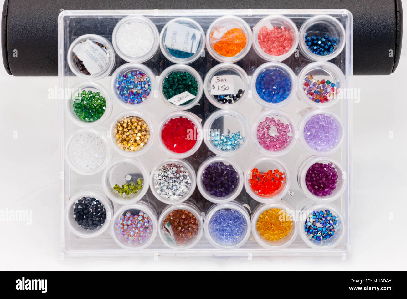 Una scatola piena di multicolori perline di sementi Foto Stock