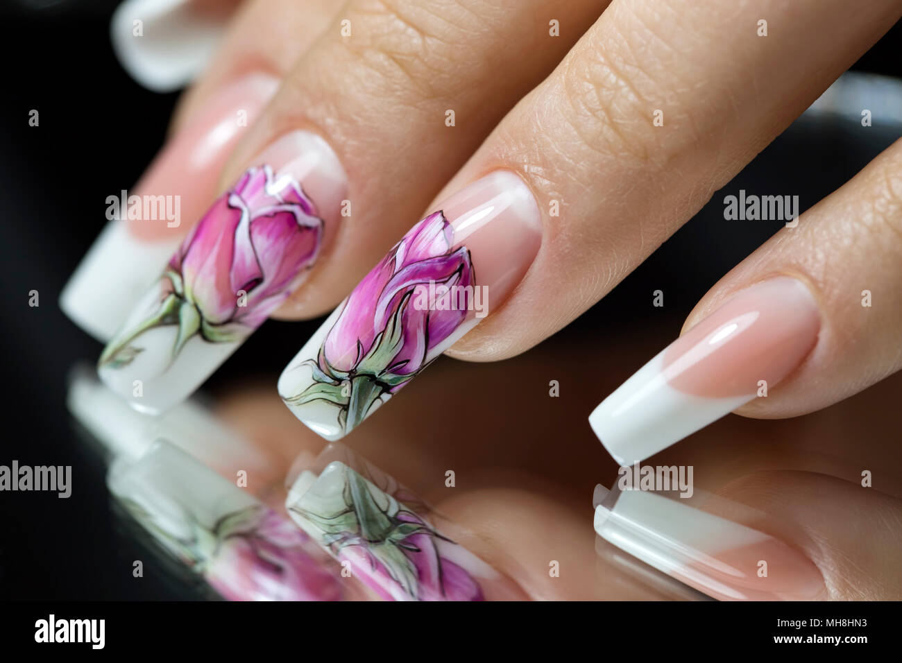 Bellissimi fiori multicolore su uno smalto trasparente sulle unghie sullo  specchio Foto stock - Alamy