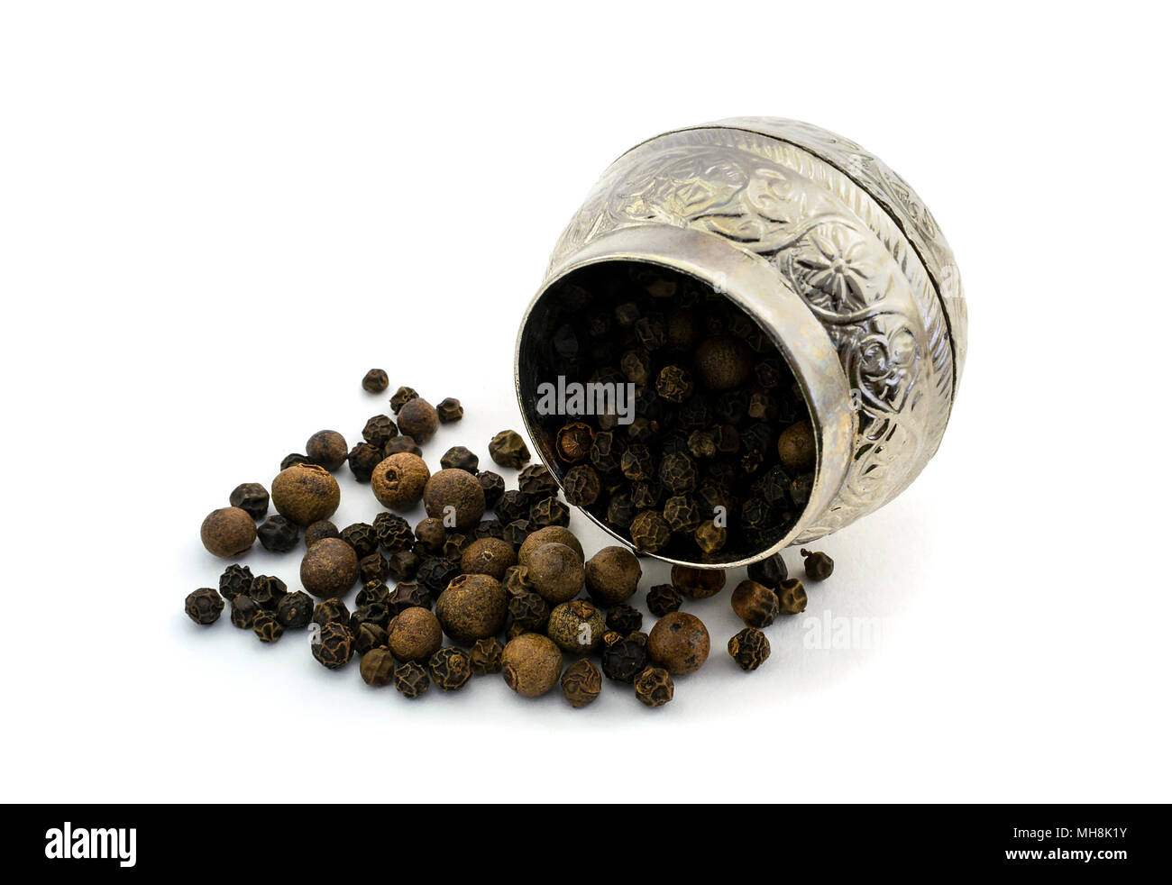 Spezie nero piselli cosparsi di pepe accanto al vintage piatti di metallo. Foto. Foto Stock