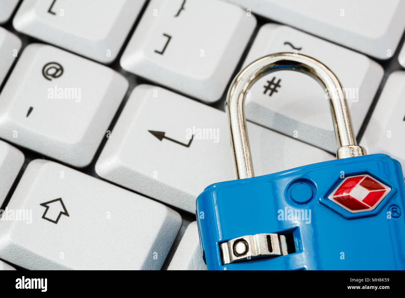Una tastiera con il tasto invio e un lucchetto TSA per illustrare online cyber security e la protezione dei dati concetto. Incentrato sul lucchetto. Inghilterra, Regno Unito, Gran Bretagna Foto Stock