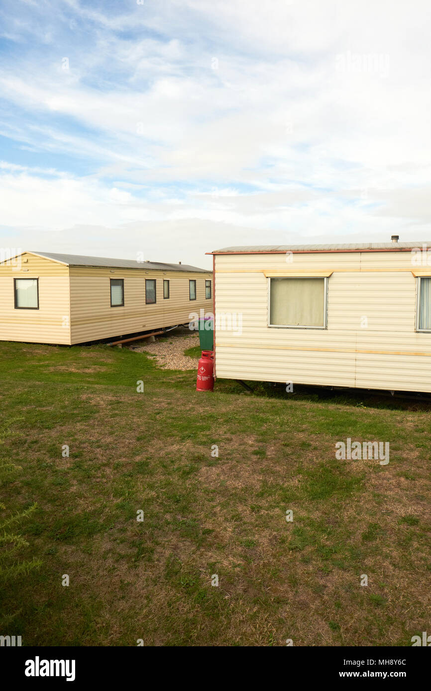 Case statiche mobili in un parco caravan in Inghilterra con bombole di gas rosse esterne Foto Stock