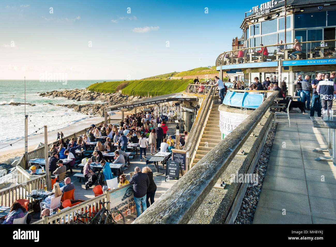 I turisti a Fistral Beach Bar godendo il sole serale in Newquay in Cornovaglia. Foto Stock