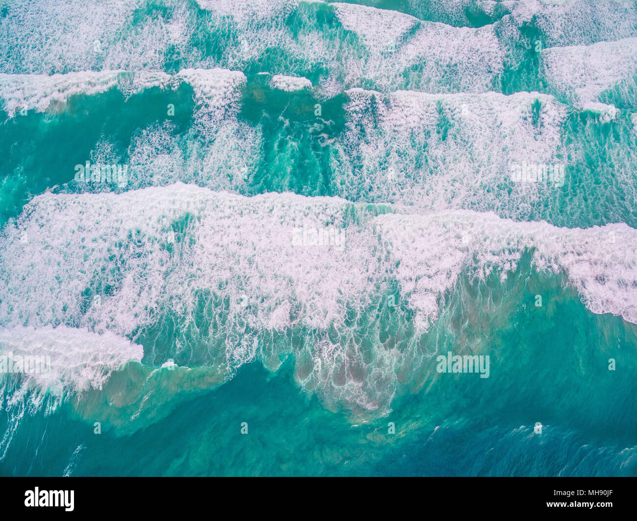 Guardando verso il basso al potente oceano turchese onde - vista aerea Foto Stock