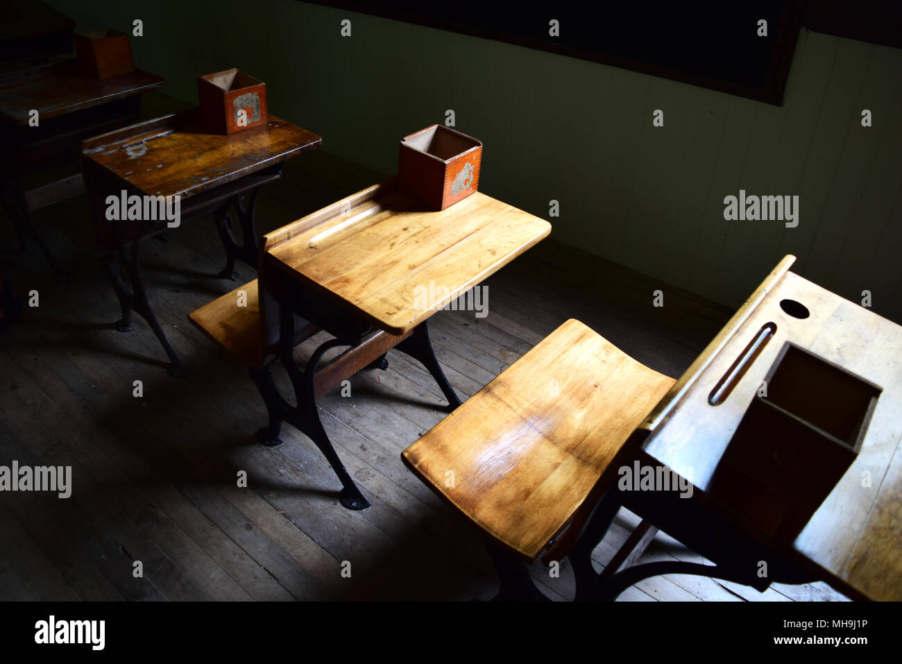 Il sole illumina il tempo vecchi banchi di scuola. Foto Stock