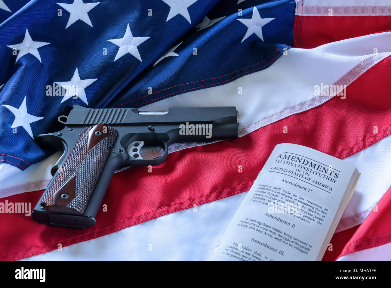 Il secondo emendamento e il controllo dell'arma negli Stati Uniti il concetto. Una pistola e la costituzione americana sulla bandiera degli Stati Uniti. Foto Stock