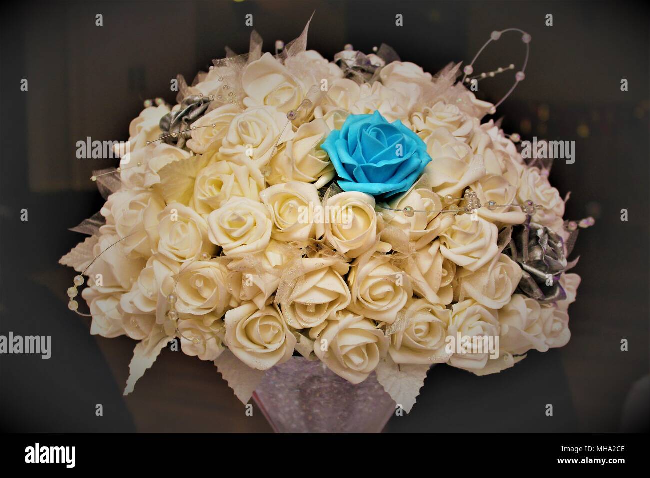 Un close-up di un bouquet di rose bianche decorare un tavolo a un ricevimento di matrimonio. Foto Stock