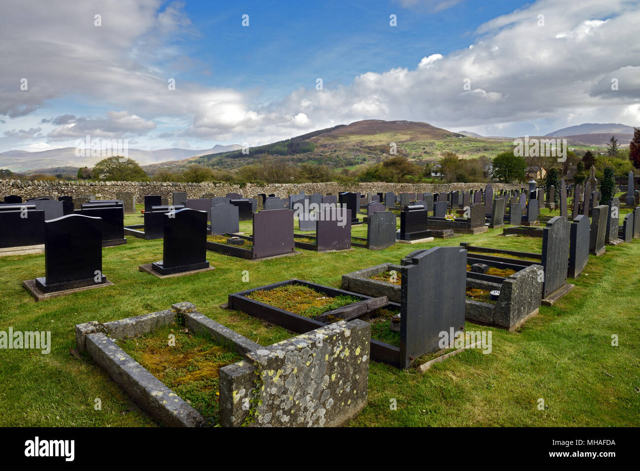 St Cedol il cimitero, Pentir, il Galles del Nord, con la montagna di Moel y Ci in background. Foto Stock