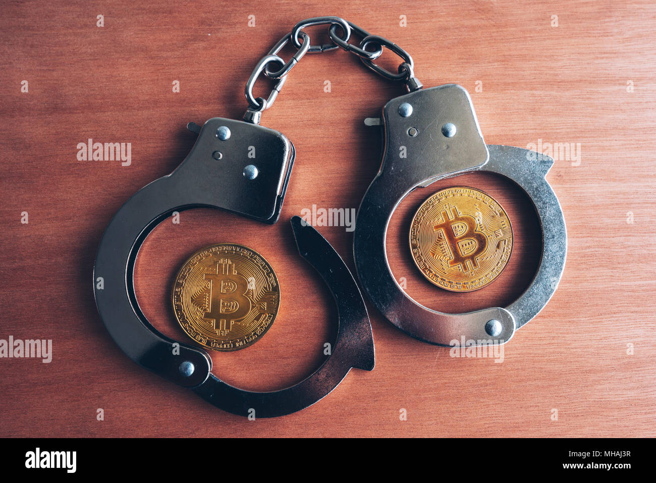 Le manette e bitcoins, immagine concettuale per cryptocurrency correlati arresto di polizia Foto Stock