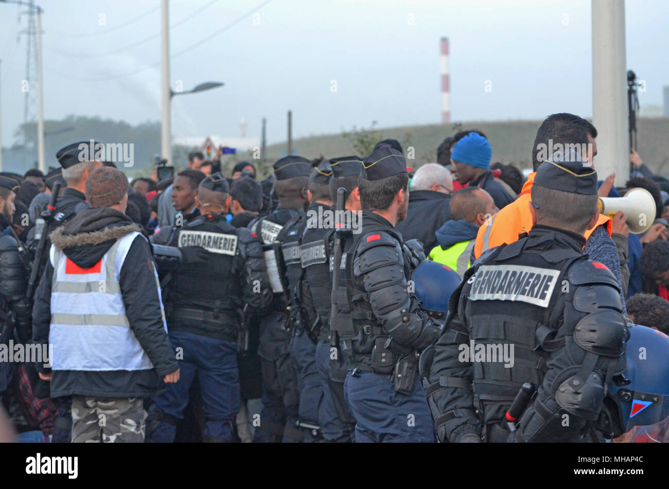 La gendarmeria francese guardare oltre la situazione durante la evacuazione della giungla. La giungla è stato un migrante illegale camp nel nord della cittadina francese di Calais. Il camp ha attratto i migranti e i rifugiati provenienti da tutto il Medio Oriente e il Nord Africa e Africa sub-sahariana che ha intenzione di entrare illegalmente nel Regno Unito. Infine le autorità francesi sono state costrette a chiudere la giungla perché era cresciuto al di fuori del controllo e stava diventando sia un pericolo per la sanità pubblica e un hub di attività criminale. La giungla di Calais è stato chiuso nel mese di ottobre 2016. Foto Stock