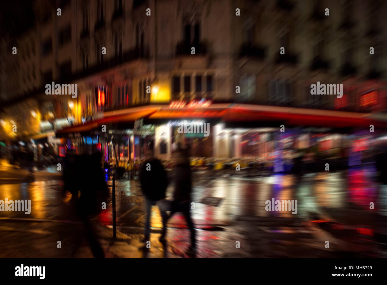 Sfocate immagini di movimento delle persone che camminano sulla strada di notte a Parigi. Foto Stock