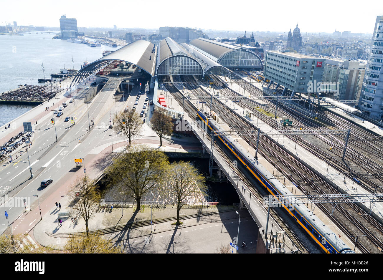 Vista aerea di Amsterdam e Centraal Station che mostra le soluzioni per la mobilità (treni sulle ferrovie, automobili sulle strade, navi traghetto per vie d'acqua), Amsterdam Foto Stock