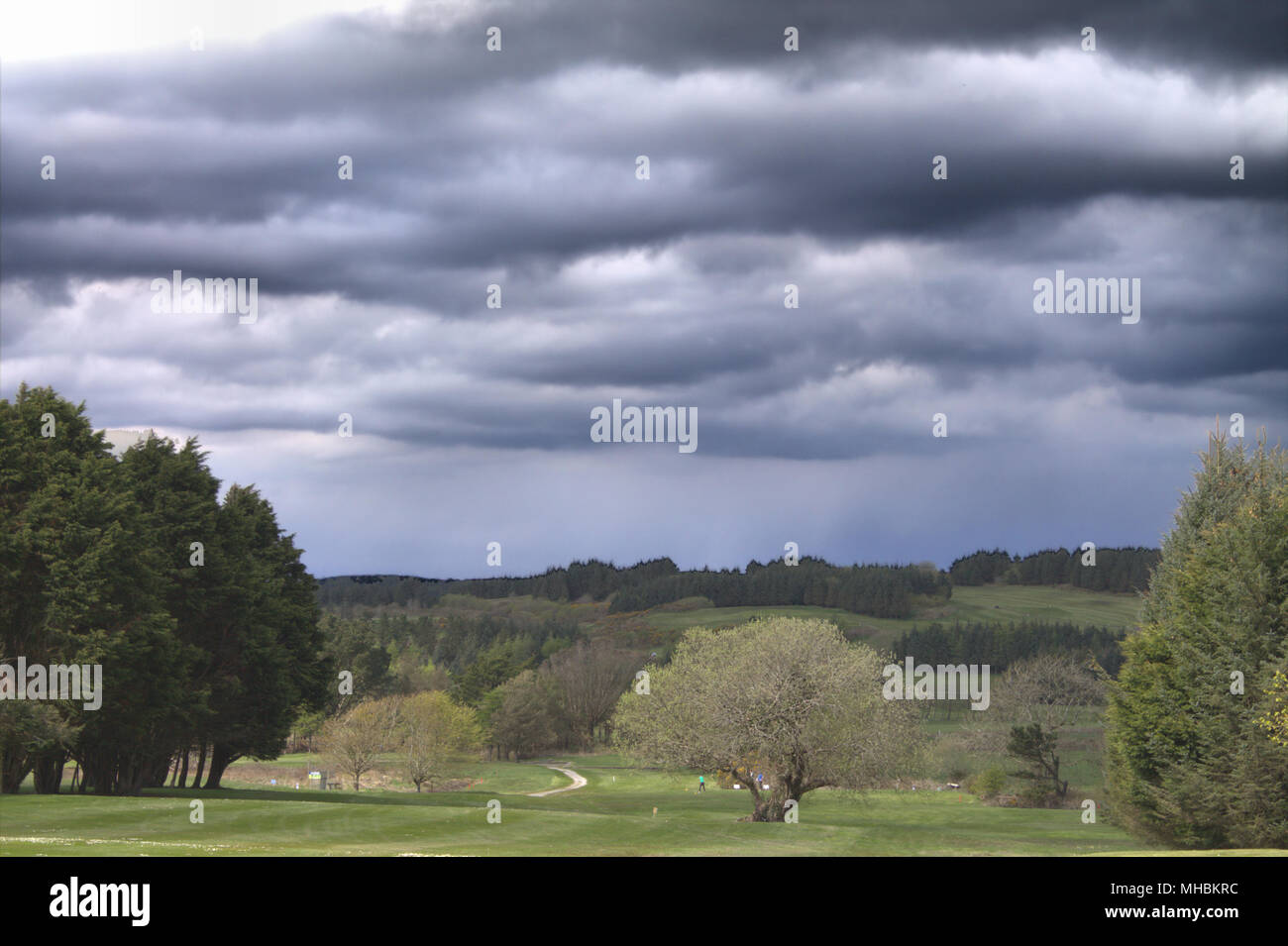 Tempesta nuvole raccogliendo oltre i giocatori su un campo da golf. Foto Stock