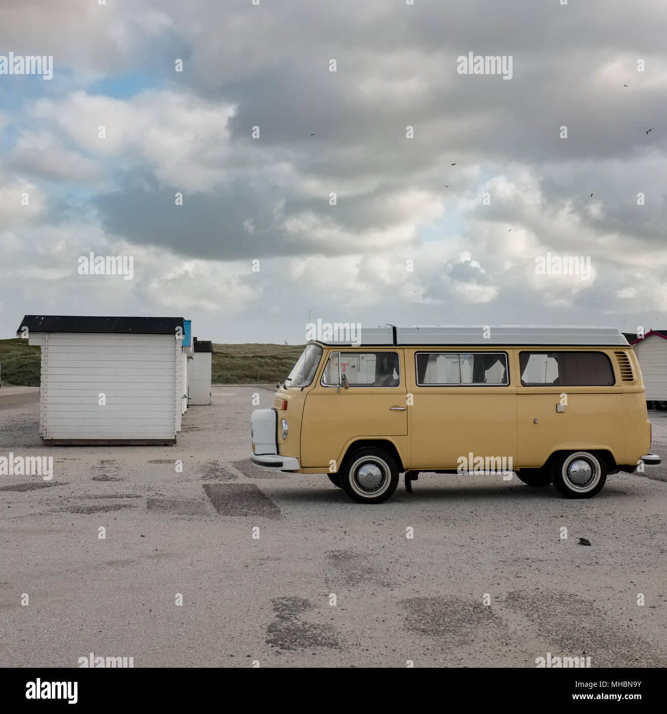 Vecchia Volkswagen van e cabine da spiaggia su una spiaggia deserta su Texel, Paesi Bassi. Foto Stock