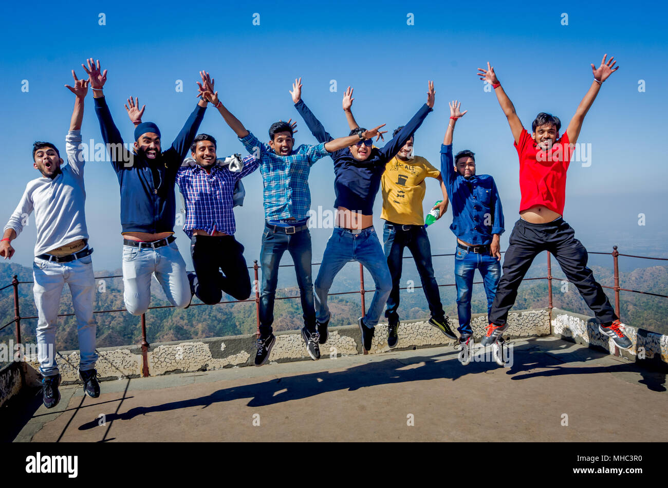 KUMBHALGARH, India - 21 novembre 2016: gruppo di felice giovani studenti indiani godendo le vacanze estive con allegro insieme di salto in aria sotto il blu sk Foto Stock