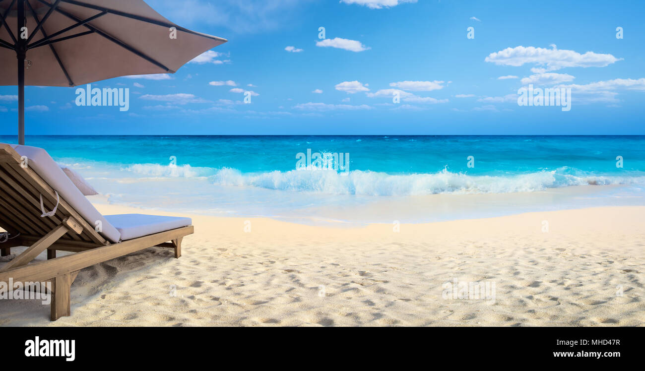 Sedia e ombrellone in spiaggia Foto Stock