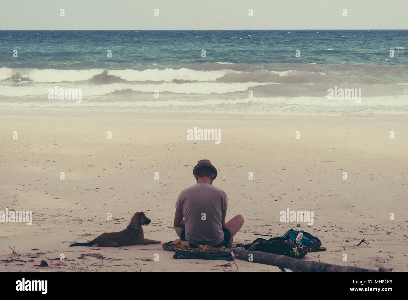 L'uomo escursionista guardando il mare cane sul sentiero sul mare. Foto Stock