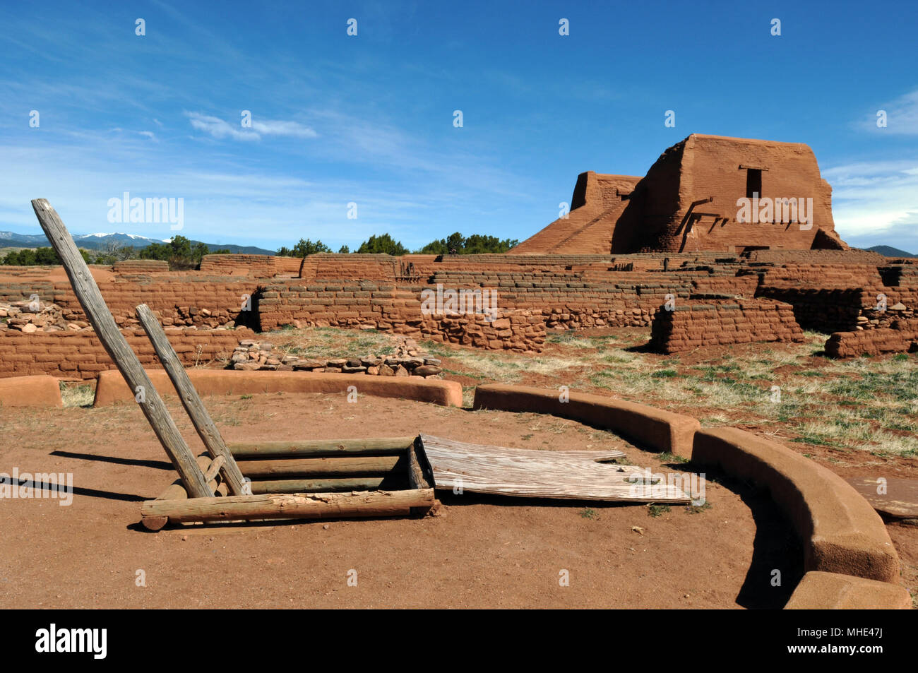 Un kiva cerimoniale sorge nei pressi del adobe resti di una missione spagnola chiesa a Pecos National Historic Park, sito del Pecos Pueblo, in New Mexico. Foto Stock