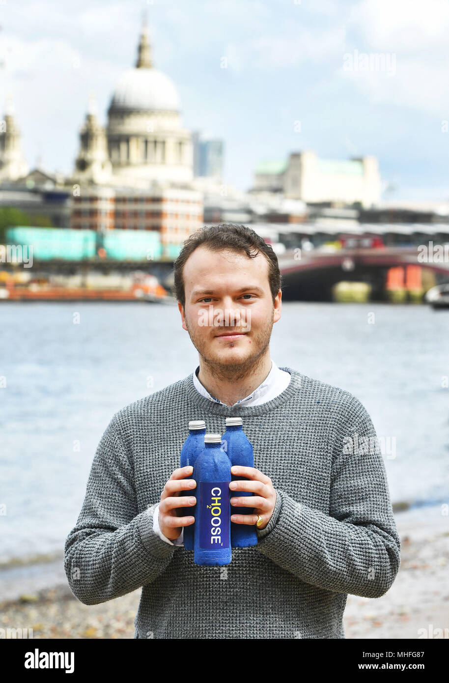 Imprenditore James Longcroft sulla South Bank di Londra centrale, tenendo tre delle sue bottiglie inventò che quando è immerso in acqua si dissolve lontano completamente, e può contribuire a fermare l'aumento dei rifiuti di plastica inquinamento dei mari del mondo. Foto Stock