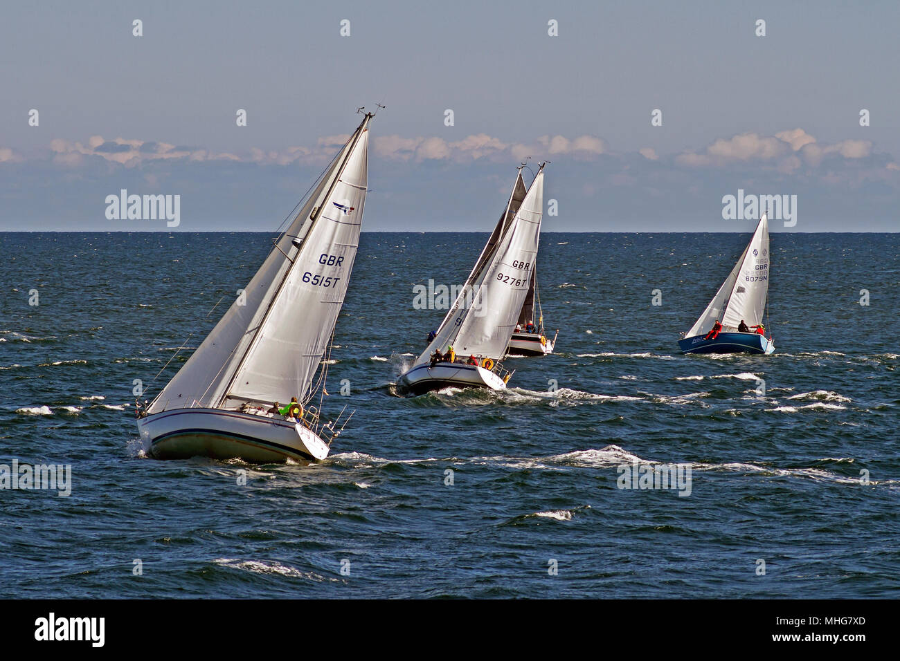 Barche a vela jockey per posizione in una competizione off Scarborough castello del promontorio. Foto Stock