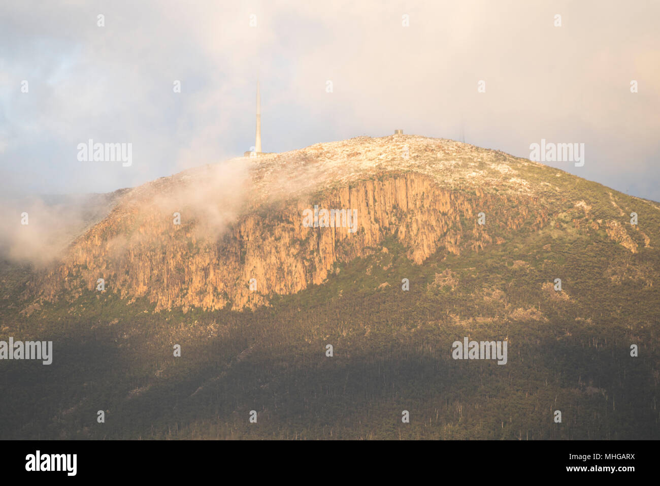 Prima luce su un nuvoloso, neve spolverata Monte Wellington al di sopra di Hobart Foto Stock
