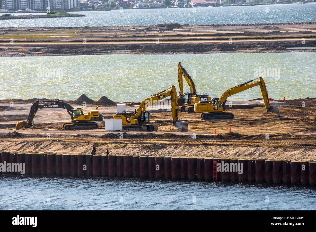 Quattro grandi giallo JCB meccanica escavatrice lavorando sul dock di Copenhagen Foto Stock