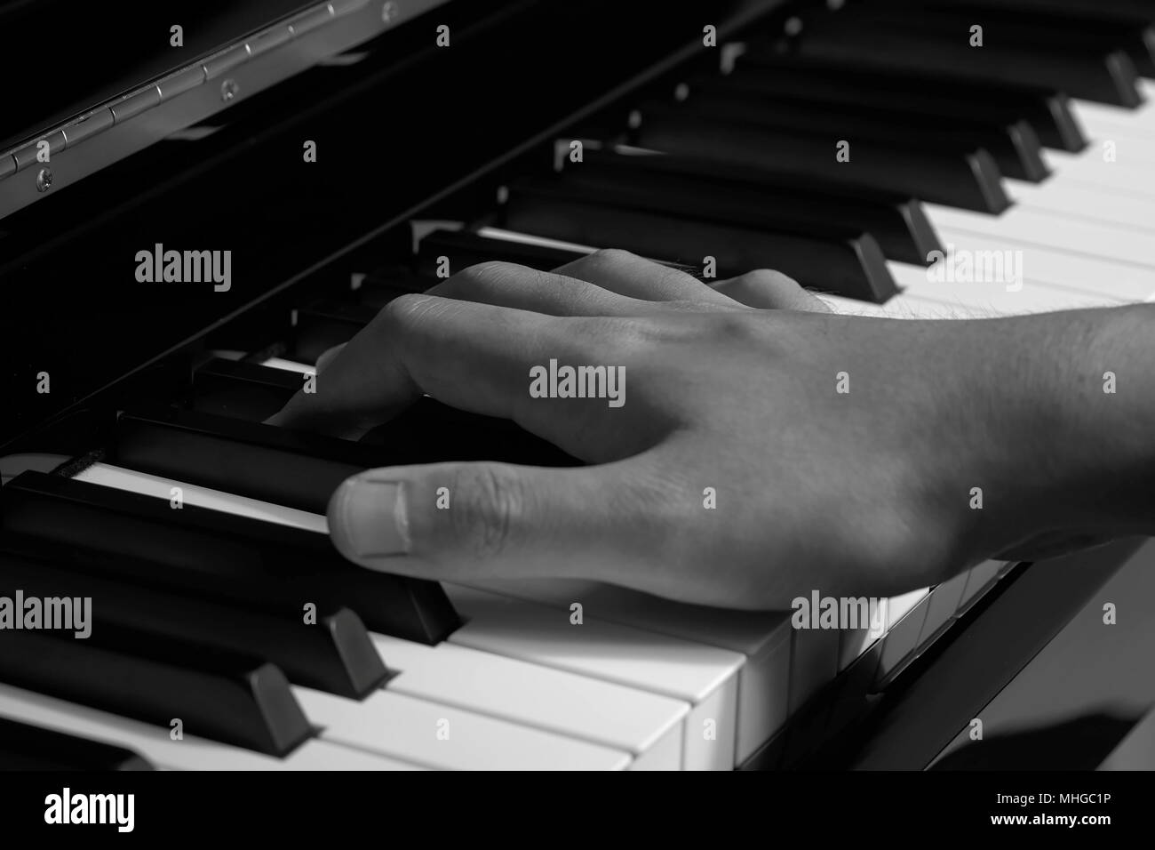 L'uomo suonare il pianoforte in studio con mano sfocata,nero e il tono di colore bianco Foto Stock