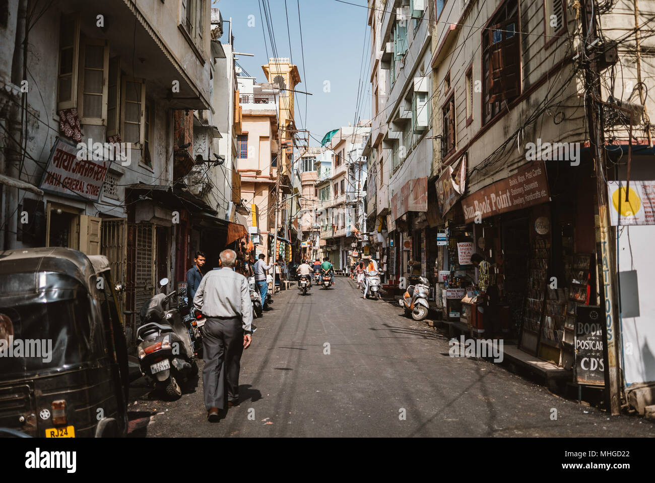 Indian uomo a camminare giù per una strada tranquilla in una calda giornata di caduta in Udaipur, India Foto Stock