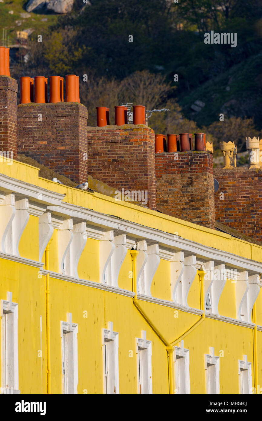 Dipinto luminosamente pensioni e chimnies presso la popolare località balneare di Llandudno, Wales, Regno Unito su una mattina di sole Foto Stock