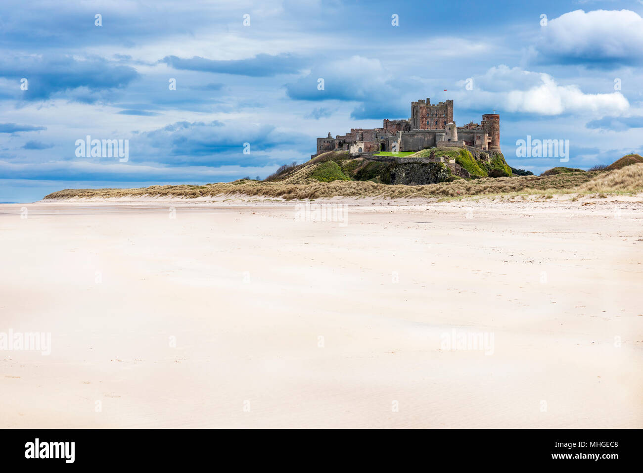 Il castello di Bamburgh, Bamburgh, Northumberland dalla sabbia bianca quando la marea è fuori. In Inghilterra. Foto Stock