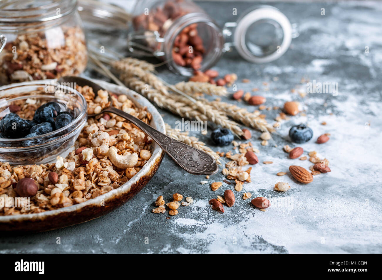 Muesli muesli o in una ciotola con un cucchiaio, mirtilli e i dadi. Una sana prima colazione Foto Stock