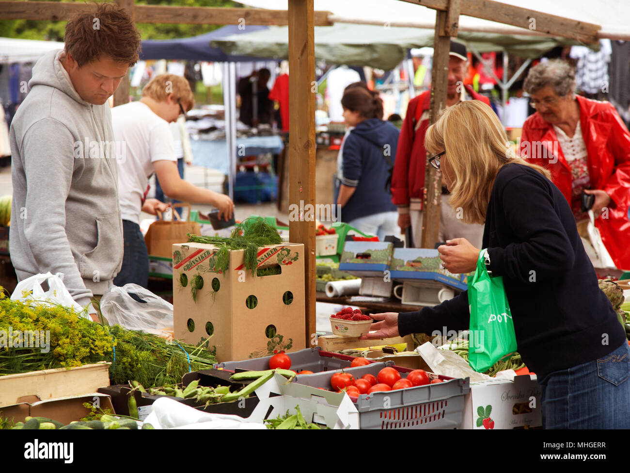 Sodertalje, Svezia - Luglio 16, 2012: i mercati degli agricoltori in piazza in Sodertalje. I clienti si vede la ricerca tra la fornitura di verdure. Foto Stock