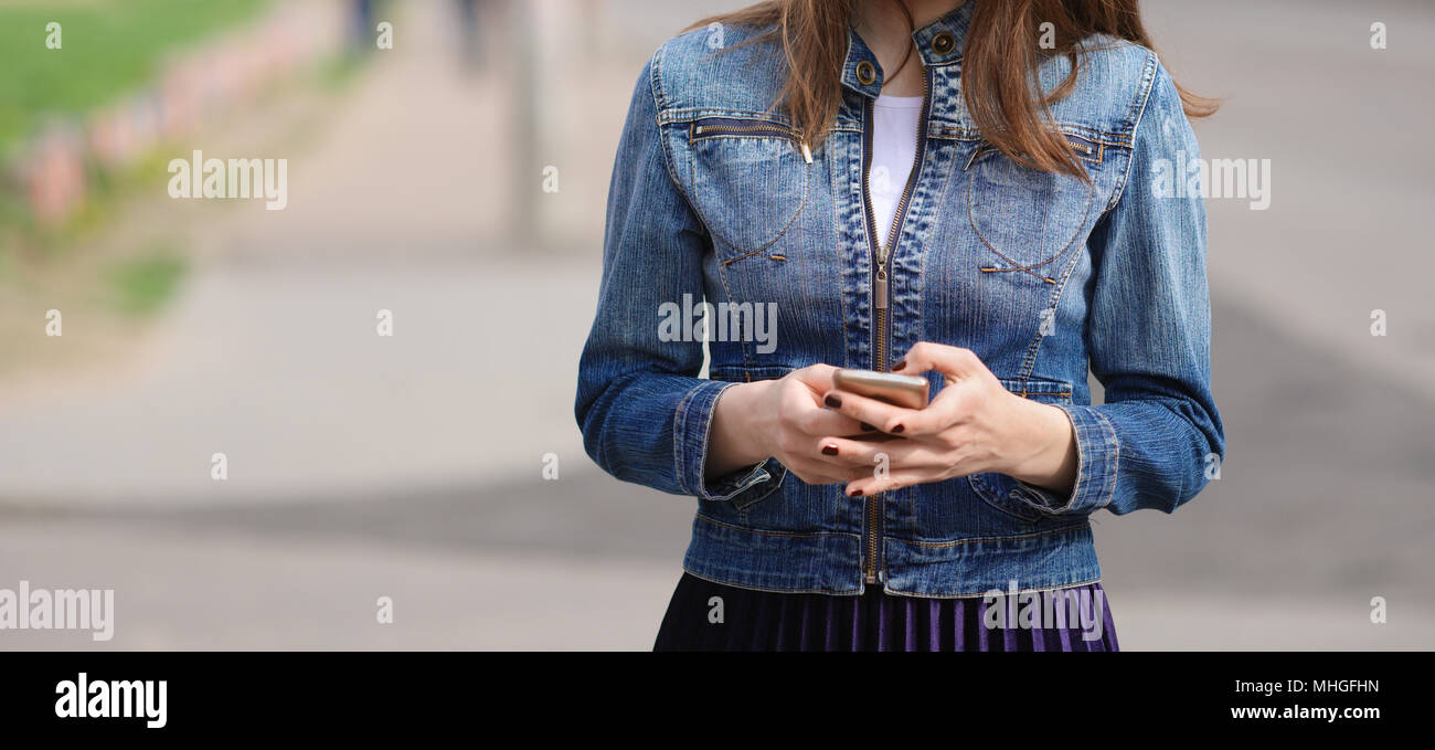 Studente guardando smart phoneduring mobile della pausa. Gli adolescenti la dipendenza da nuove tendenze tecnologiche. Nuova generazione di problema. Foto Stock