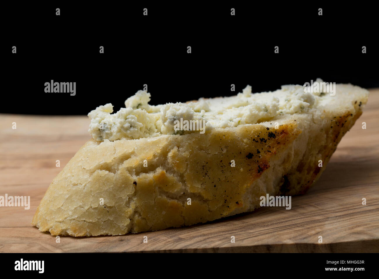 Francese di formaggio Boursin acquistato da un supermercato nel Regno Unito spalmato su una fetta di pane bianco. Boursin è un pieno di grasso morbido formaggio di latte di mucca flav Foto Stock