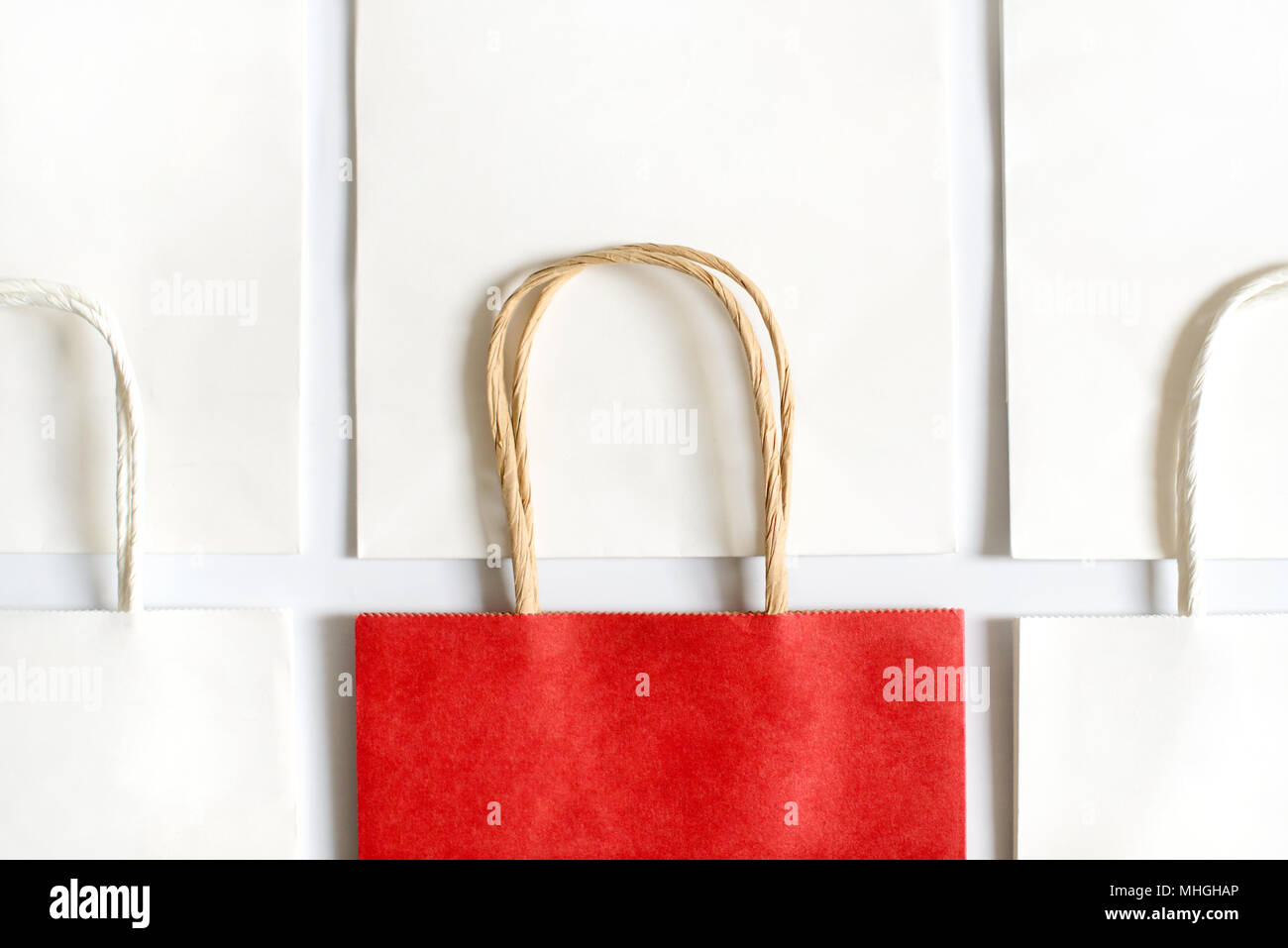 Uno rosso shopping bag in background di sacchetti bianchi isolati su sfondo bianco. Venerdì nero o vendite di Natale. Foto Stock
